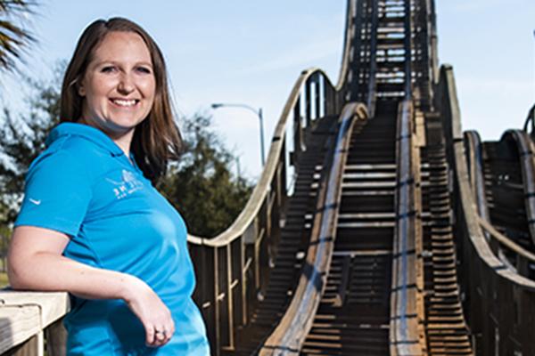 alumni standing by rollercoaster she engineered